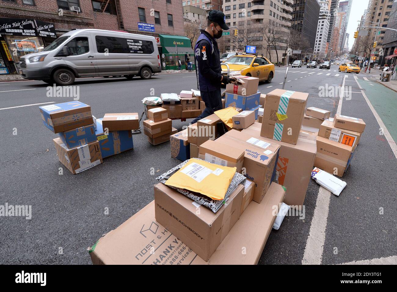 New York, USA. 24th Dec, 2020. Sprawled out on Second Avenue behind his truck, a FEDEX worker sorts out packages to be delivered on Christmas Eve, New York, NY, December 24, 2020. With a resurgence in COVID-19 infections, package shipping services such as FEDEX, UPS and the USPS are expecting to deliver a record number of packages for 2020. (Photo by Anthony Behar/Sipa USA) Credit: Sipa USA/Alamy Live News Stock Photo