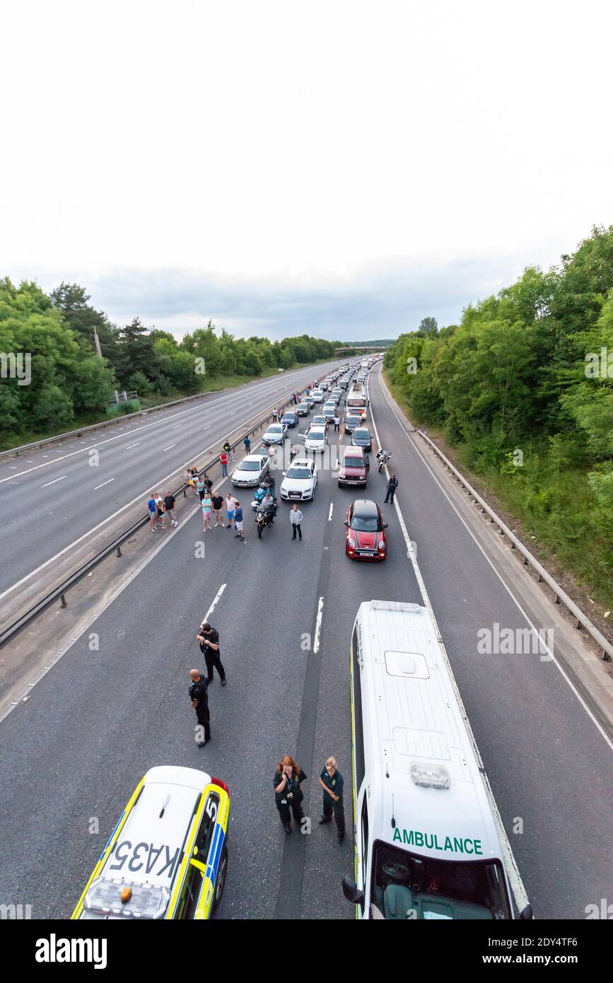 Traffic stopped on the M11 motorway due to a serious road accident which closed the highway in both directions. People out of their cars. Stationary Stock Photo