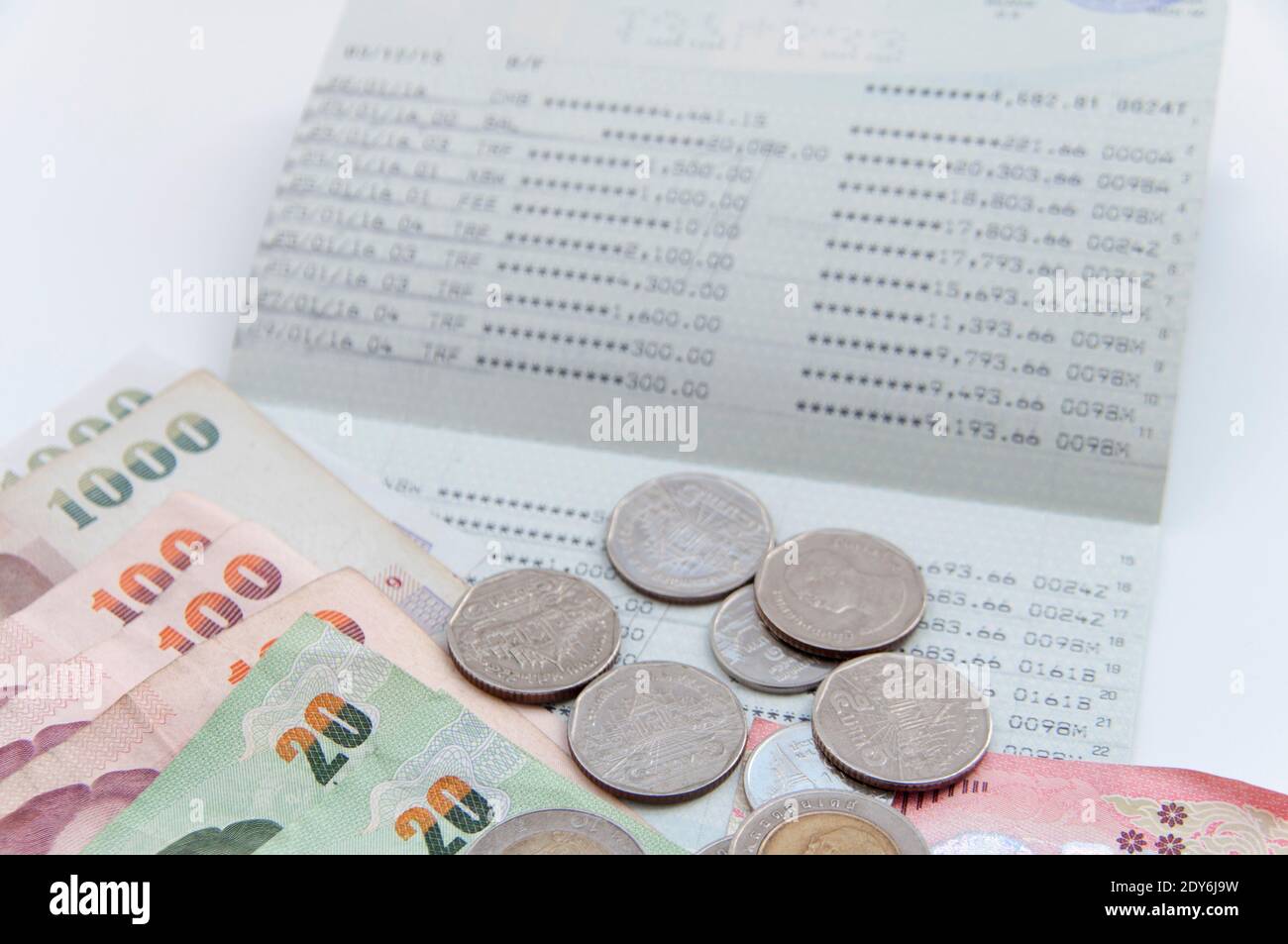 Close-up Of Currency And Passbook On White Background Stock Photo