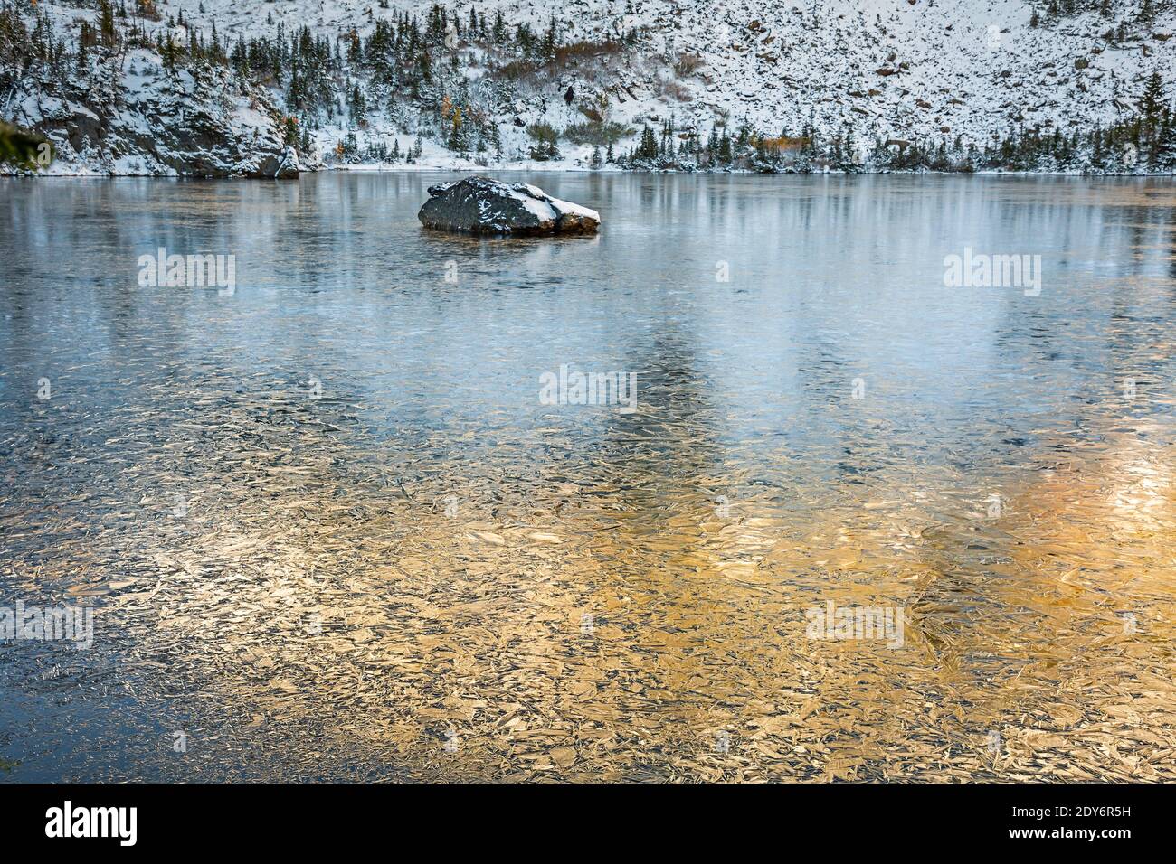 WA18823-00...WASHINGTON - Sunlight reflecting on the ice covered water of Lake Ethel in the Alpine Lakes Wilderness. Stock Photo