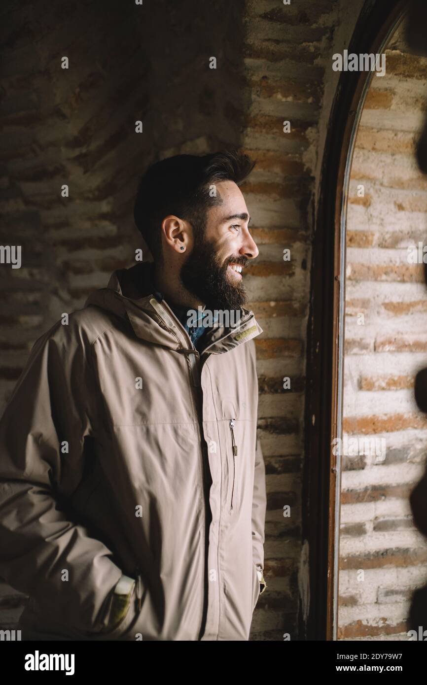Smiling bearded man looking through the window Stock Photo