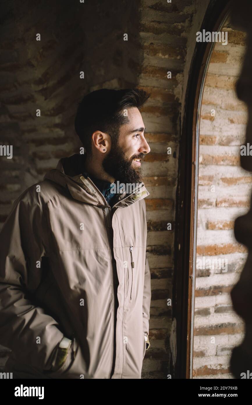 Smiling bearded man looking through the window Stock Photo