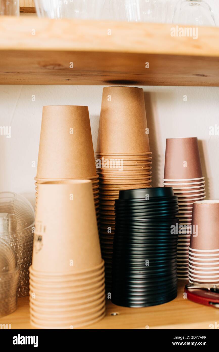 Pile of disposable paper cups turned upside down on wooden shelf Stock ...
