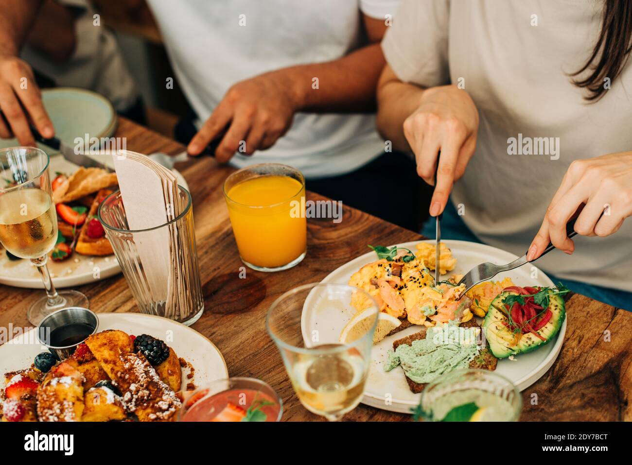 Group of people eating breakfast or brunch at table in cafe Stock Photo