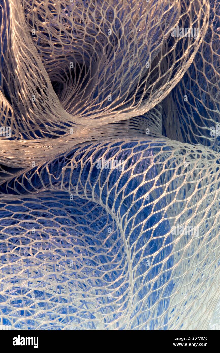 Closeup macro photograph macrophotograph of the patterns in a blue and white mesh ball used in showers showering, also called a loofah or scrunchie sk Stock Photo