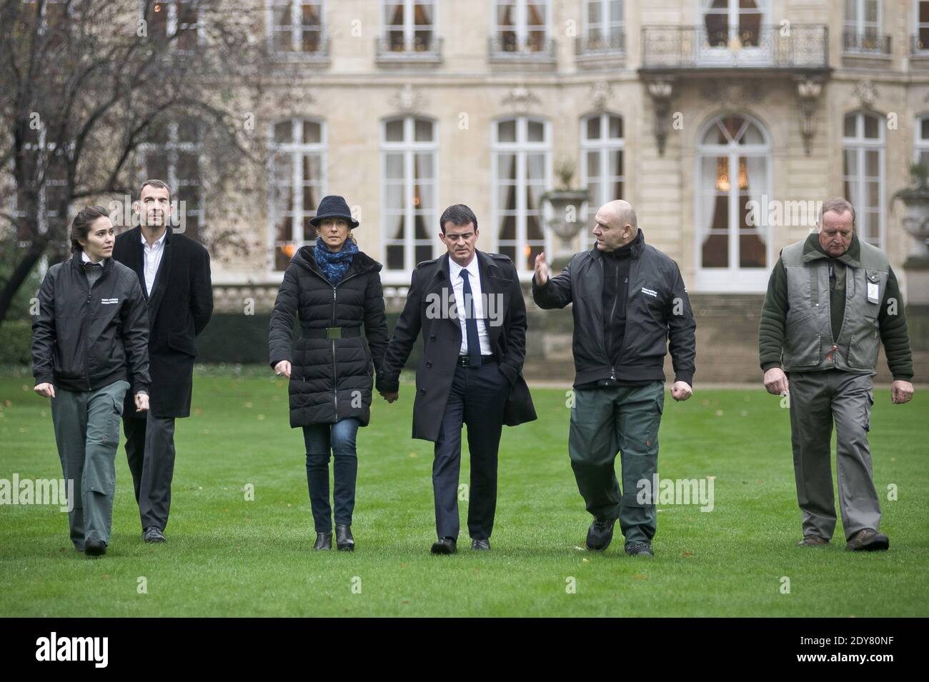French Prime Minister Manuel Valls arriving along with his wife Anne Gravoin and gardeners to plant the tree called 'of the Prime Minister' - as is the republican tradition - in the gardens of his headquarters Hotel de Matignon in Paris, France on December 16, 2014. The tree, chosen by the Prime Minister, is an oak of the species 'Quercus robur fastigiata' and is located on the front lawn. The tradition of planting a tree at the PM's headquarters was introduced by the late Prime Minister Raymond Barre in 1978. Photo Pool by Nicolas Messyasz/ABACAPRESS.COM Stock Photo