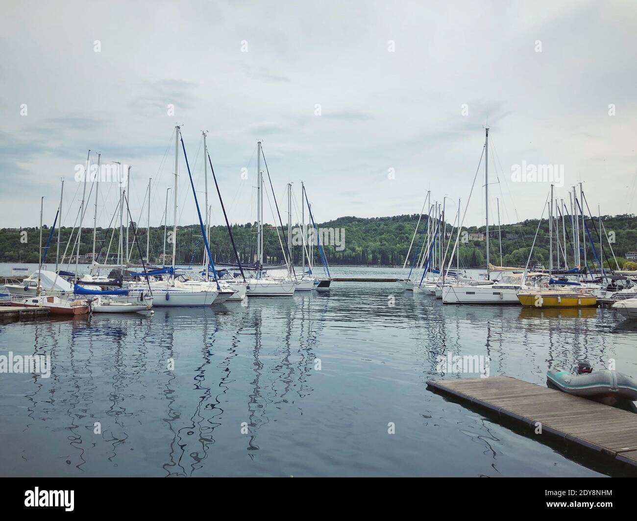 Sailboats Moored In Harbor Against Sky Stock Photo