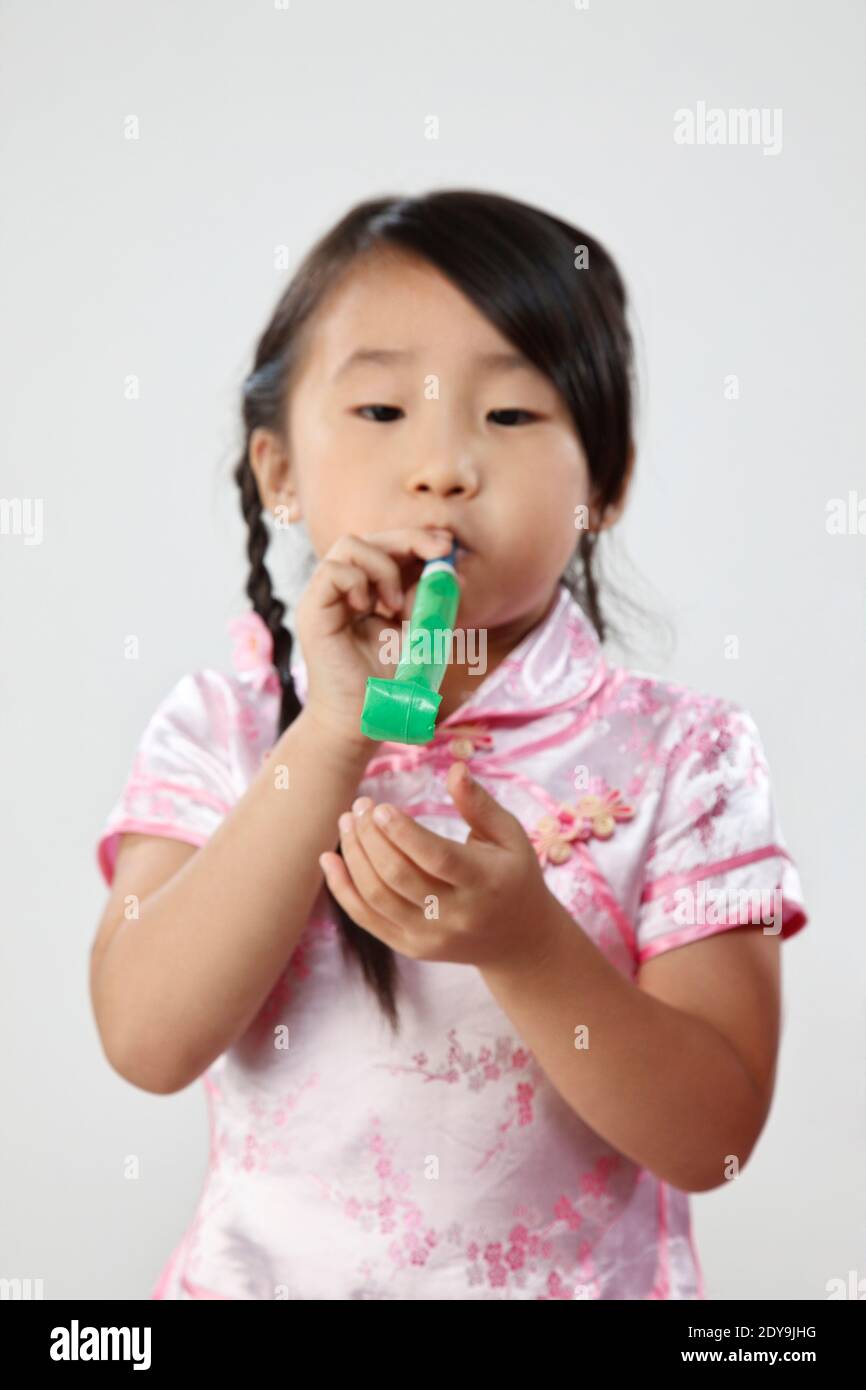 Cute Girl Playing With Party Horn Blower Against White Background Stock ...