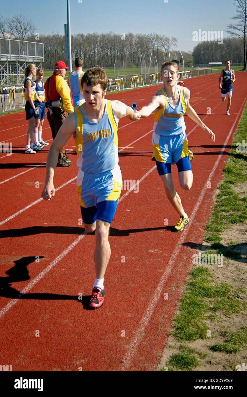 High School track and field event paticipant in the baton pass in a