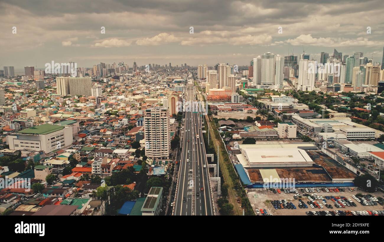 Top down traffic highway with cars, trucks aerial. Urban transportation at bridge road at metropolis city of Manila, Philippines, Asia. Cinematic cityscape of downtown freeway drone shot Stock Photo