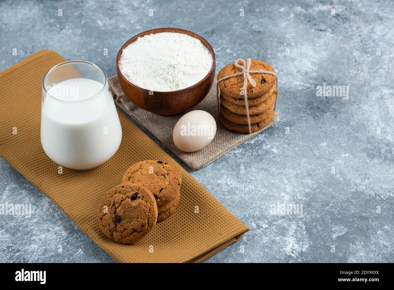 A glass of hot milk with delicious cookies on a gray background Stock Photo