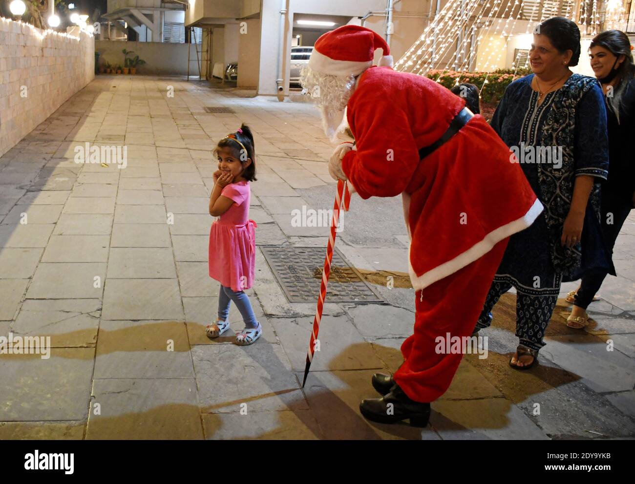 Mumbai, India. 24th Dec, 2020. A young girl interacts with Santa Claus.Kavita Patil, a young woman dressed as Santa Claus spread happiness in this difficult time of coronavirus pandemic. She interacted with the children and posed for pictures. Credit: SOPA Images Limited/Alamy Live News Stock Photo