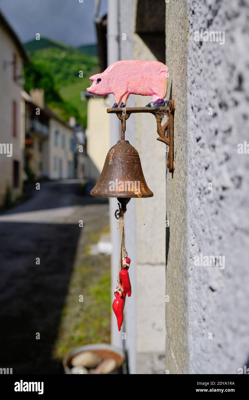 door bell chime hanging outside door with pig shaped figure above Stock Photo