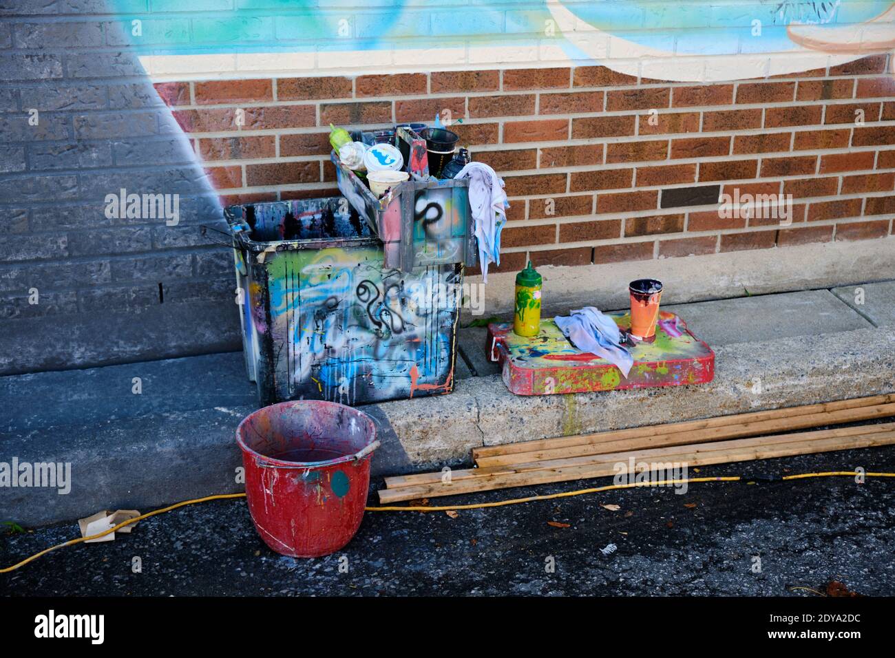 Wall art artist gear of paint , brush and bucket at foot of project