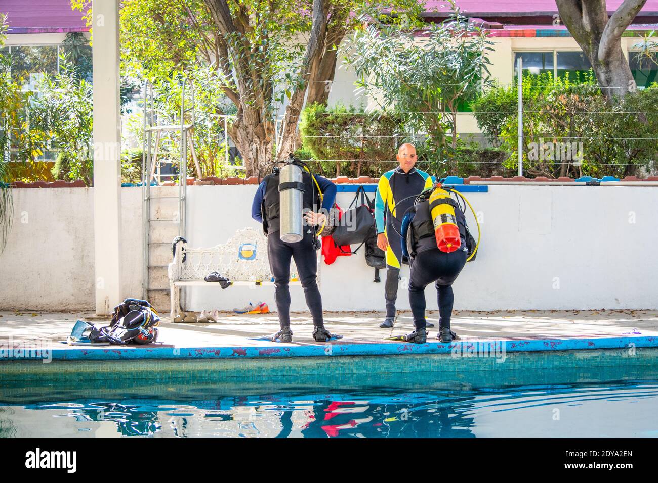 Two men on the edge of a pool before jumping into it while their