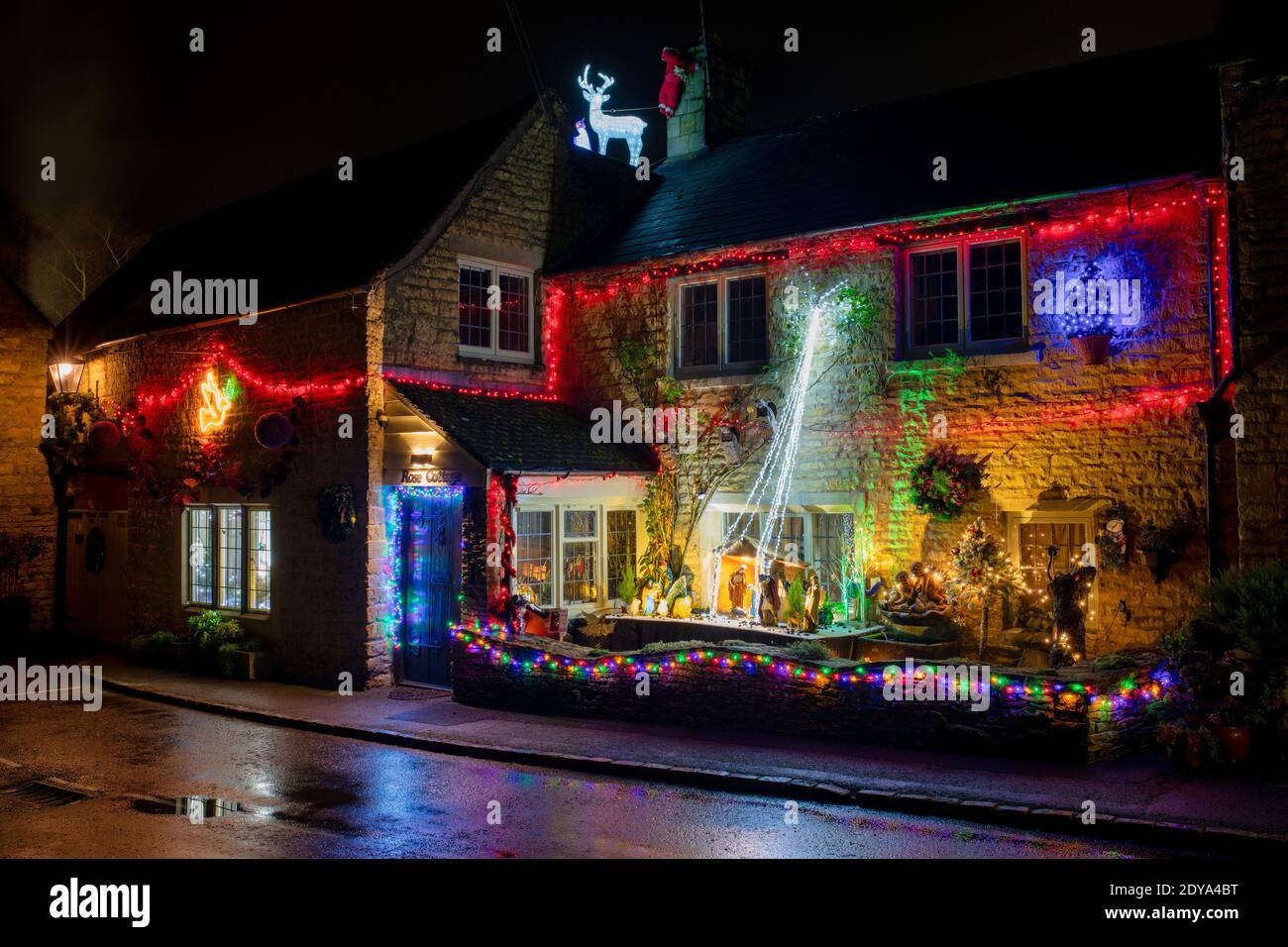 Christmas lights and nativity at night outside a cotswold stone cottage. Bourton on the Water