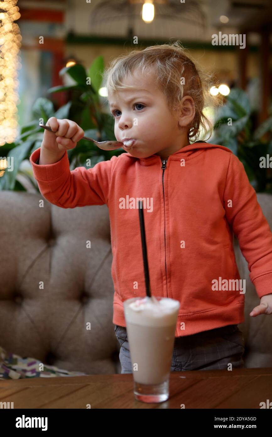 Kid eating foam of cocoa in cafe Stock Photo Alamy