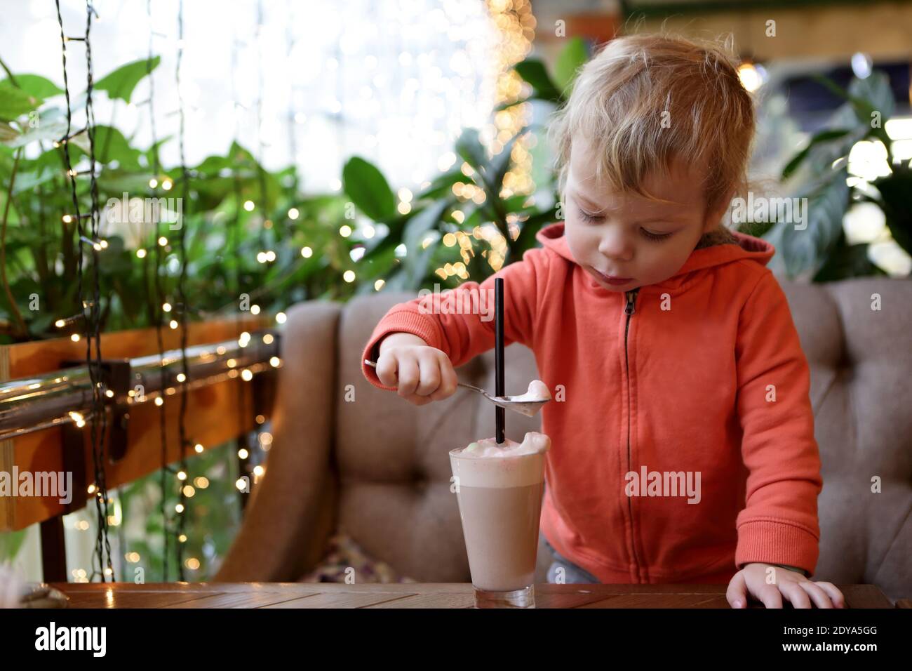 Toddler eating foam of cocoa in cafe Stock Photo Alamy