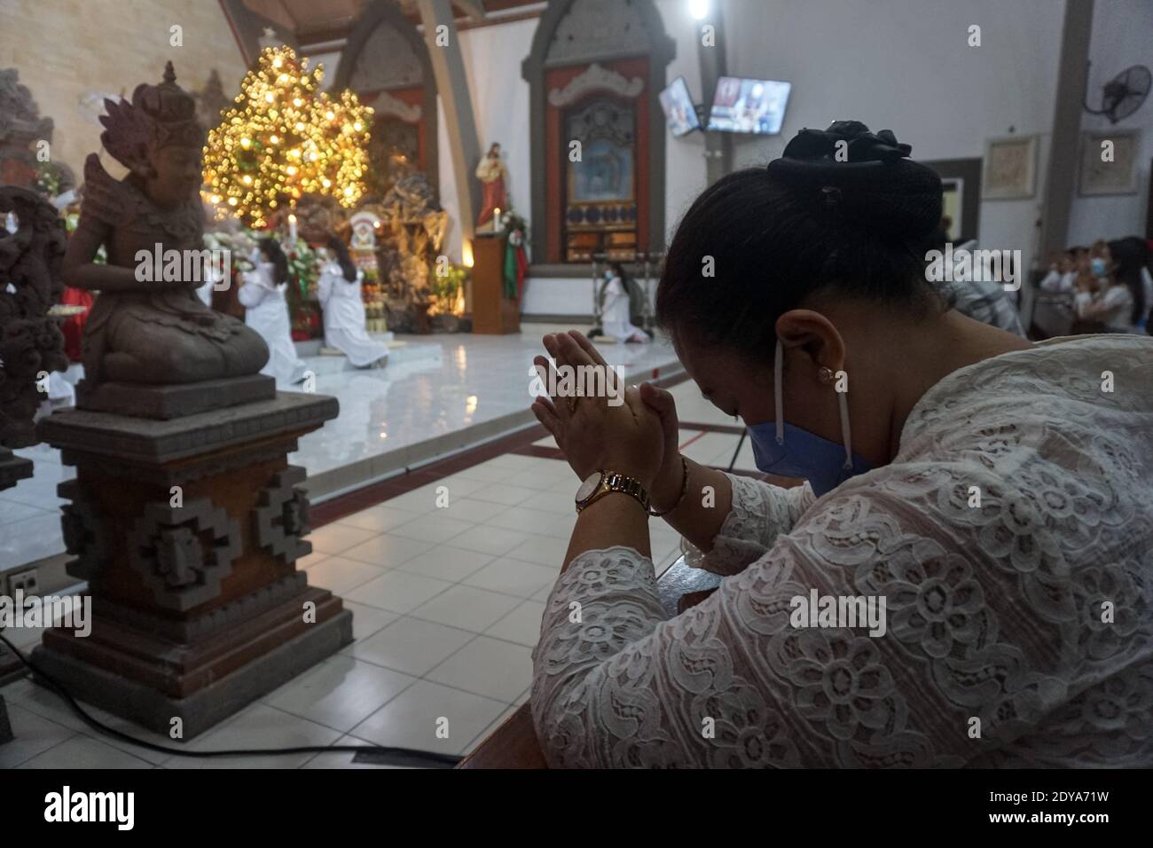 Denpasar, Bali, Indonesia. 24th Dec, 2020. Catholics wears Balinese  traditional costumes while attending Chirstmas Eve Mass Prayers in Church  of ''Roh Kudus'' (Holy Spirit) Parish, Canggu. The church to impose health  protocols