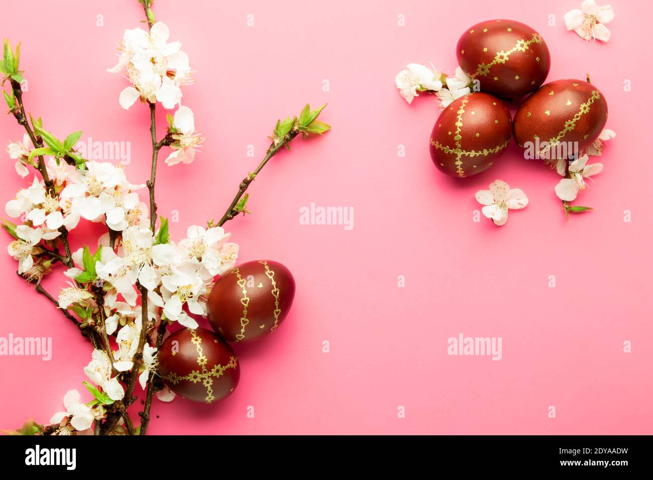 Easter pink background with Easter eggs and spring flowers. Top view ...