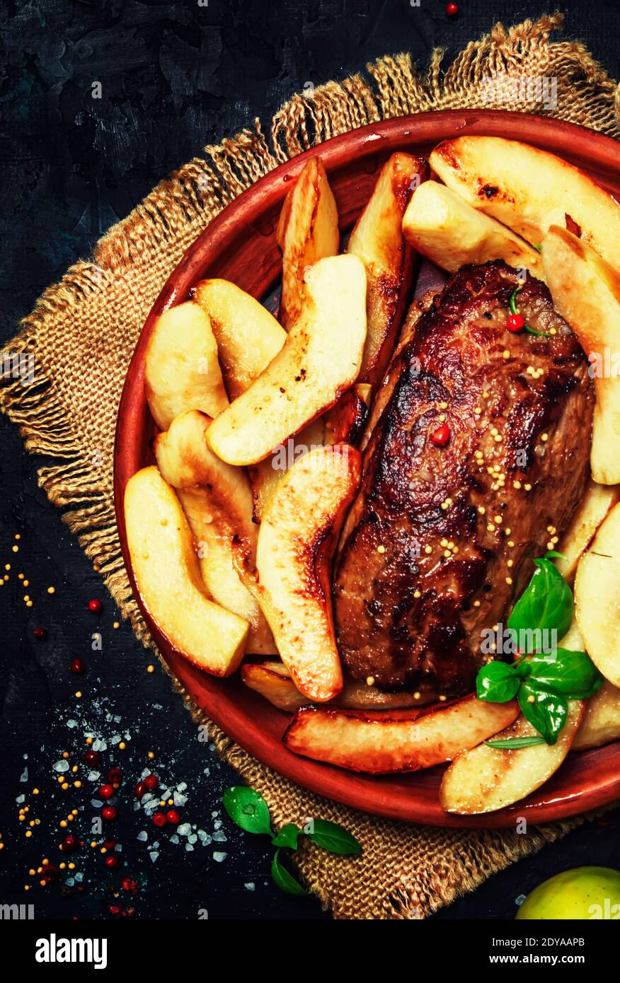 Fried pork tenderloin with quince, dark background, top view Stock