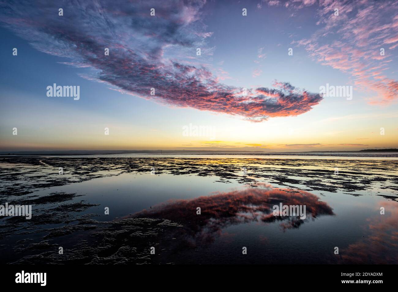Spectacular pink cloud formations at sunrise on the beach at Poona, Fraser Coast Region, Queensland, QLD, Australia Stock Photo