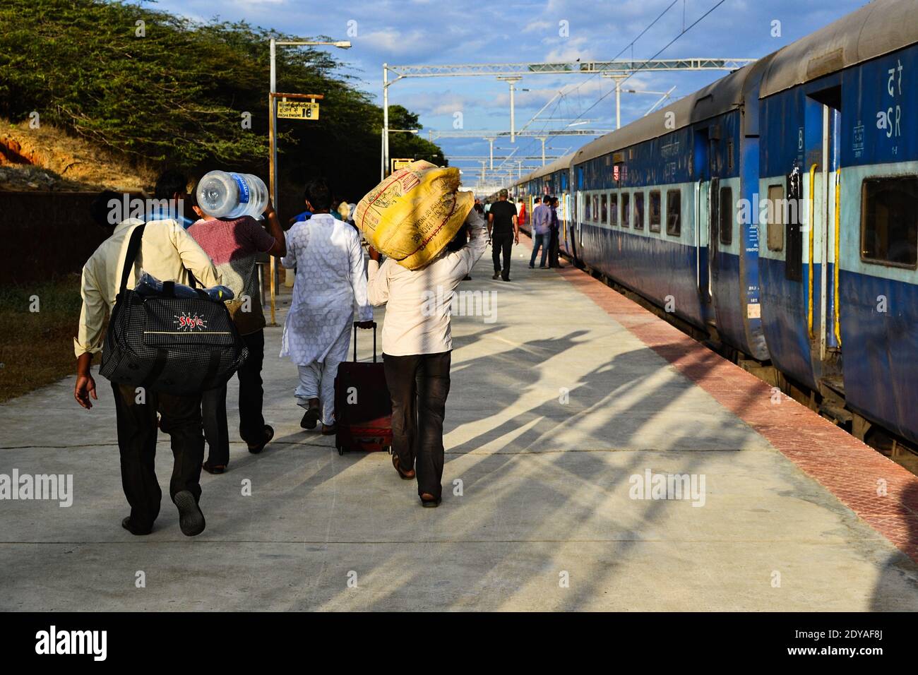 Kanyakumari, Tamil Nadu, India - January, 2017: Group of Indian men walk on platform carrying heavy bags before departure train on the railway station Stock Photo