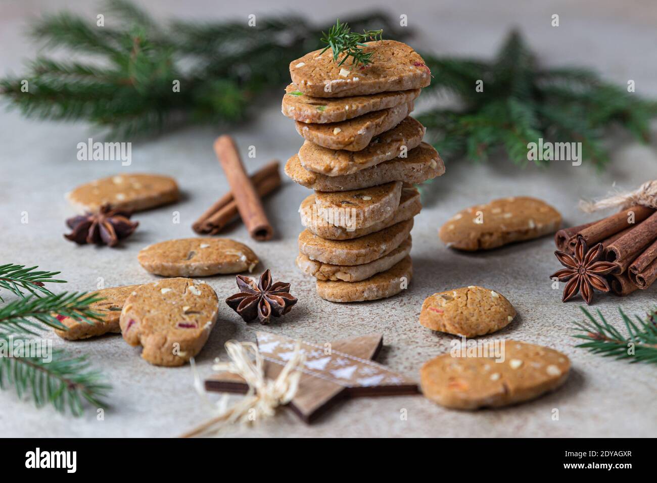 Danish spicy butter cookies with candied fruits, cinnamon sticks and anise, light background. Festive Christmas or New Year background with fir branch Stock Photo