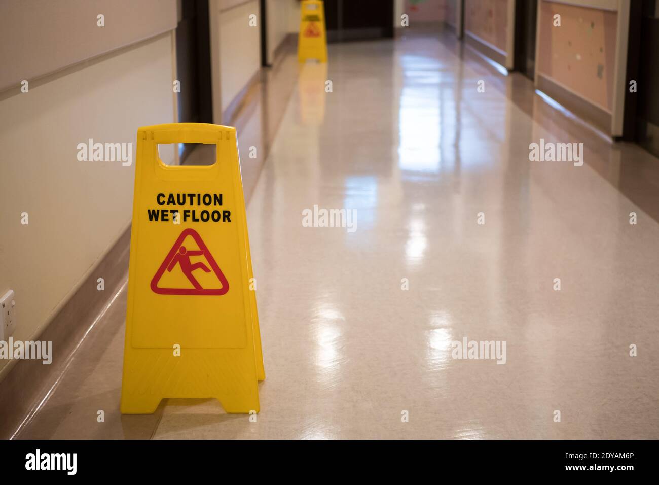 Sign showing warning of caution wet floor in hospital corridor. Stock Photo