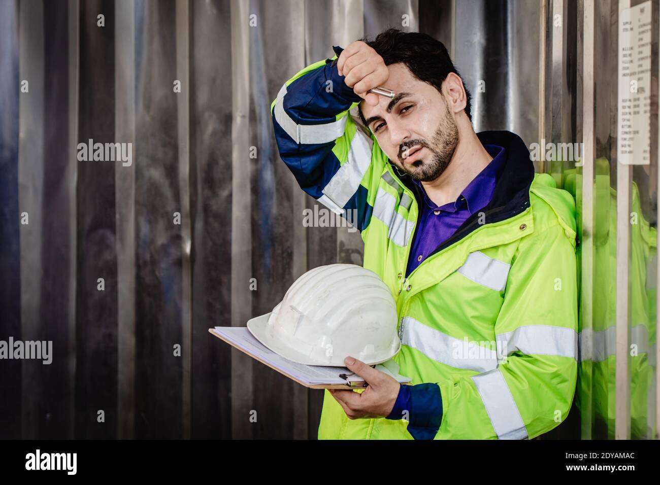 Tired worker, engineer headache hot weather over heat unhealthy working in heavy industry factory. Stock Photo