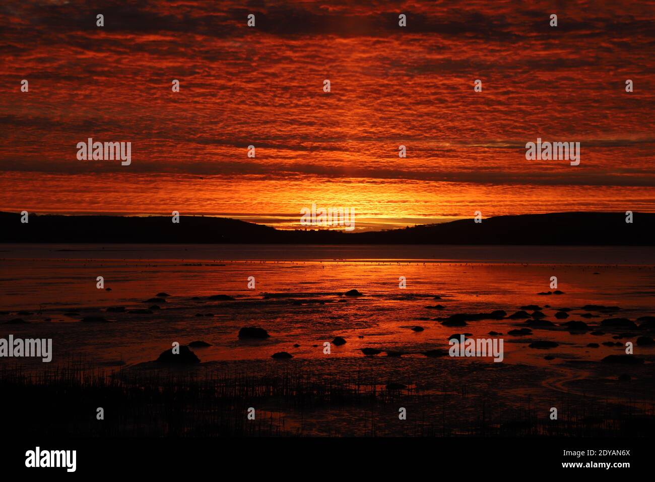 Dundee, UK. 25th December, 2020. Sunrise over Invergowrie Bay near Dundee. A dramatic start to Christmas Day. Credit: Stephen Finn/Alamy Live News Stock Photo
