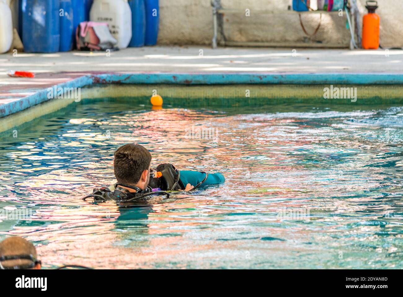 teacher diver helping a student swim during his class Stock Photo