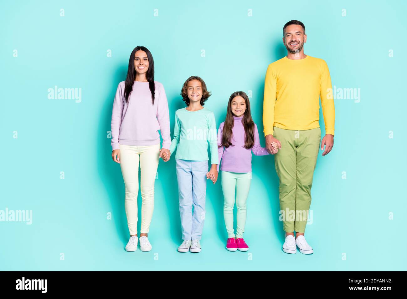 Photo portrait of big family holding hands isolated on vivid cyan colored background Stock Photo