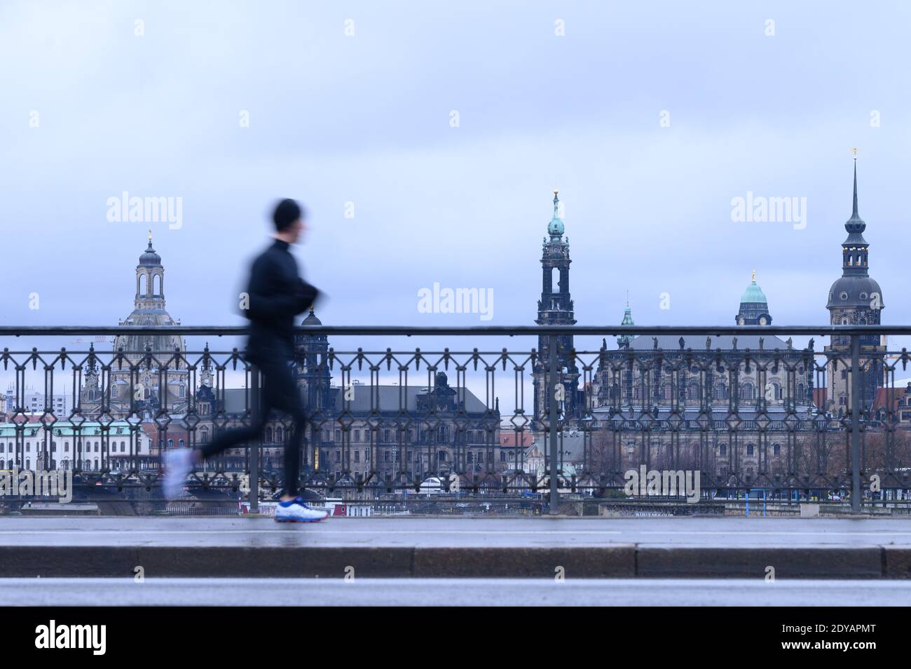 Dresden, Germany. 25th Dec, 2020. A man walks across the Marienbrücke against the backdrop of the old town. Credit: Sebastian Kahnert/dpa-Zentralbild/dpa/Alamy Live News Stock Photo