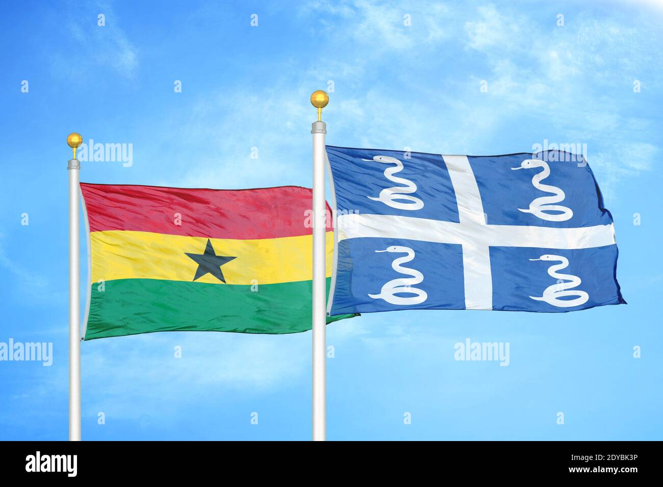 Ghana and Martinique snake two flags on flagpoles and blue sky Stock