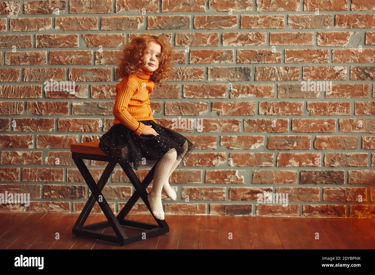 cute little girl sitting on a chair in a new living room Stock Photo ...