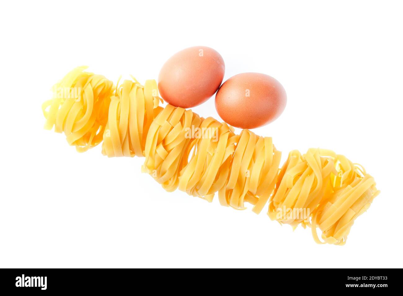 Raw dry tagliatelle noodle, eggs close up isolated on white background