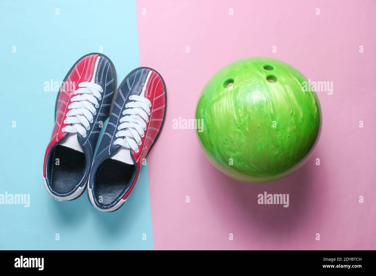 Bowling shoes and bowling ball on a pinkblue pastel background. Indoor entertainment, family
