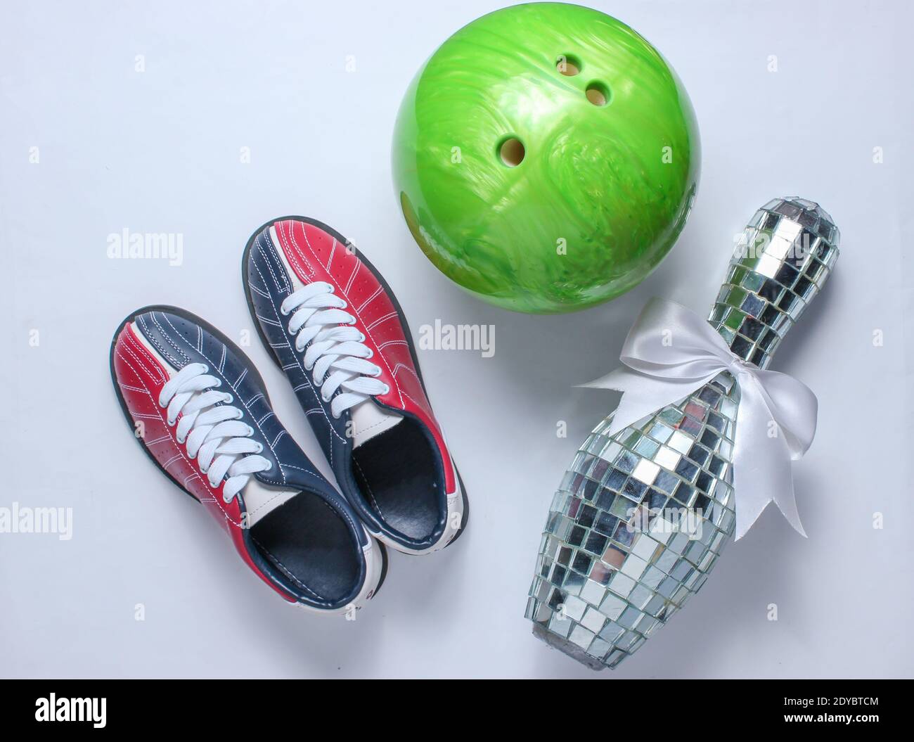 Bowling shoes, disco mirror skittle and bowling ball on white background. Indoor family sports. Top view. Flat lay. Minimalism Stock Photo