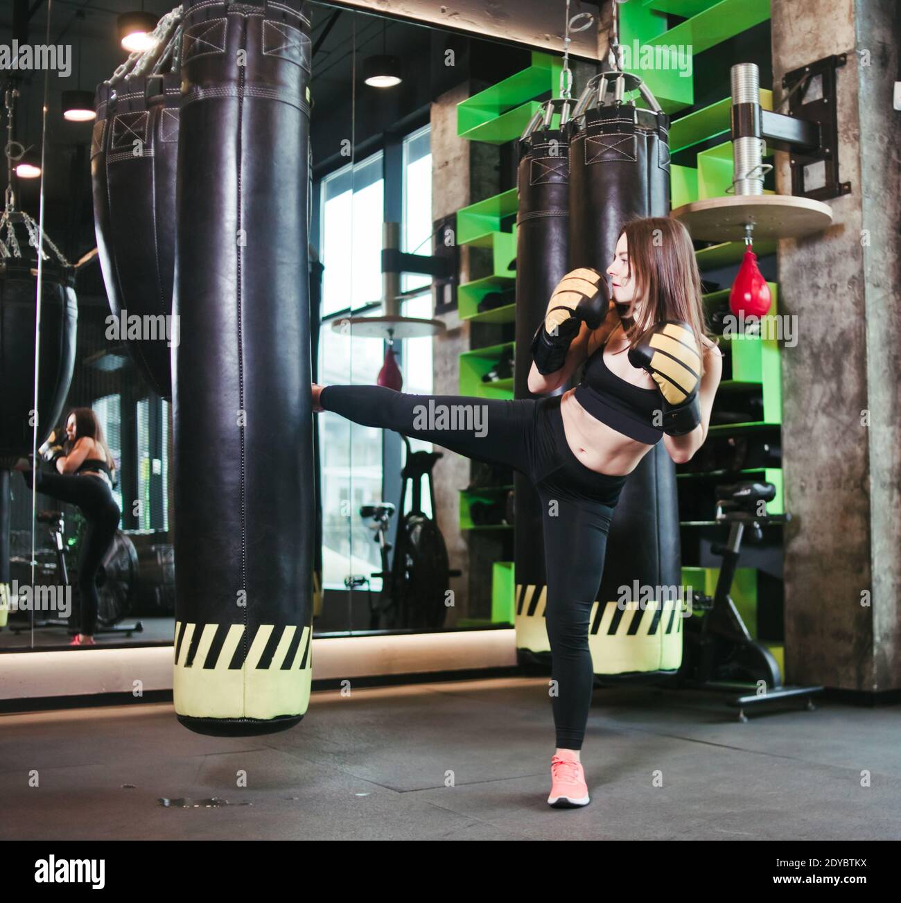 Fit Girl In Sportswear And Boxing Gloves Trains Kick Against Punching Bag At Dark Gym Women S Self Defense Training The Ability To Pinch Yourself Stock Photo Alamy