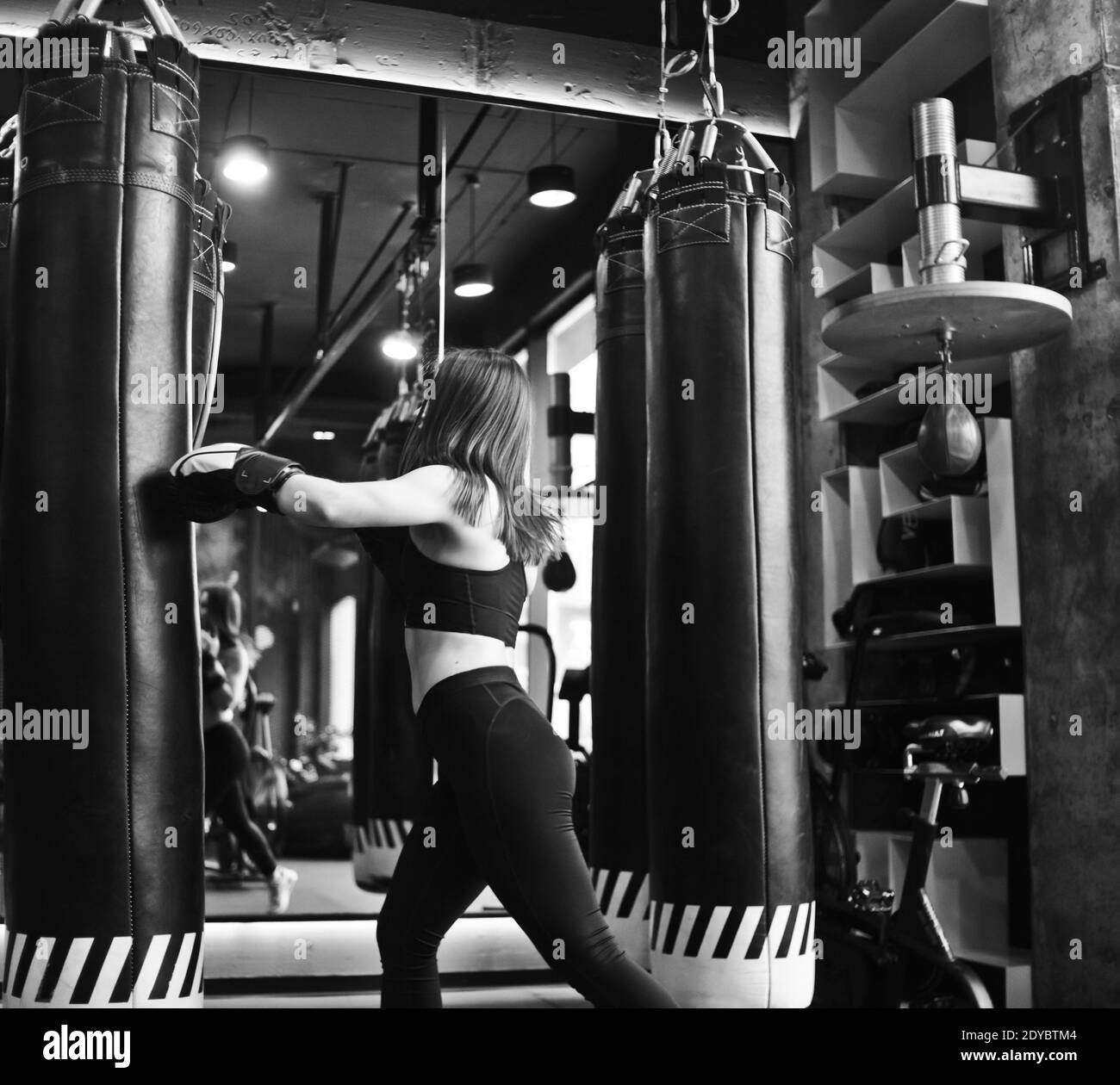 Fit Girl In Sportswear And Boxing Gloves Trains Blow Against A Punching Bag In A Dark Gym Women S Self Defense Training The Ability To Pinch Yoursel Stock Photo Alamy