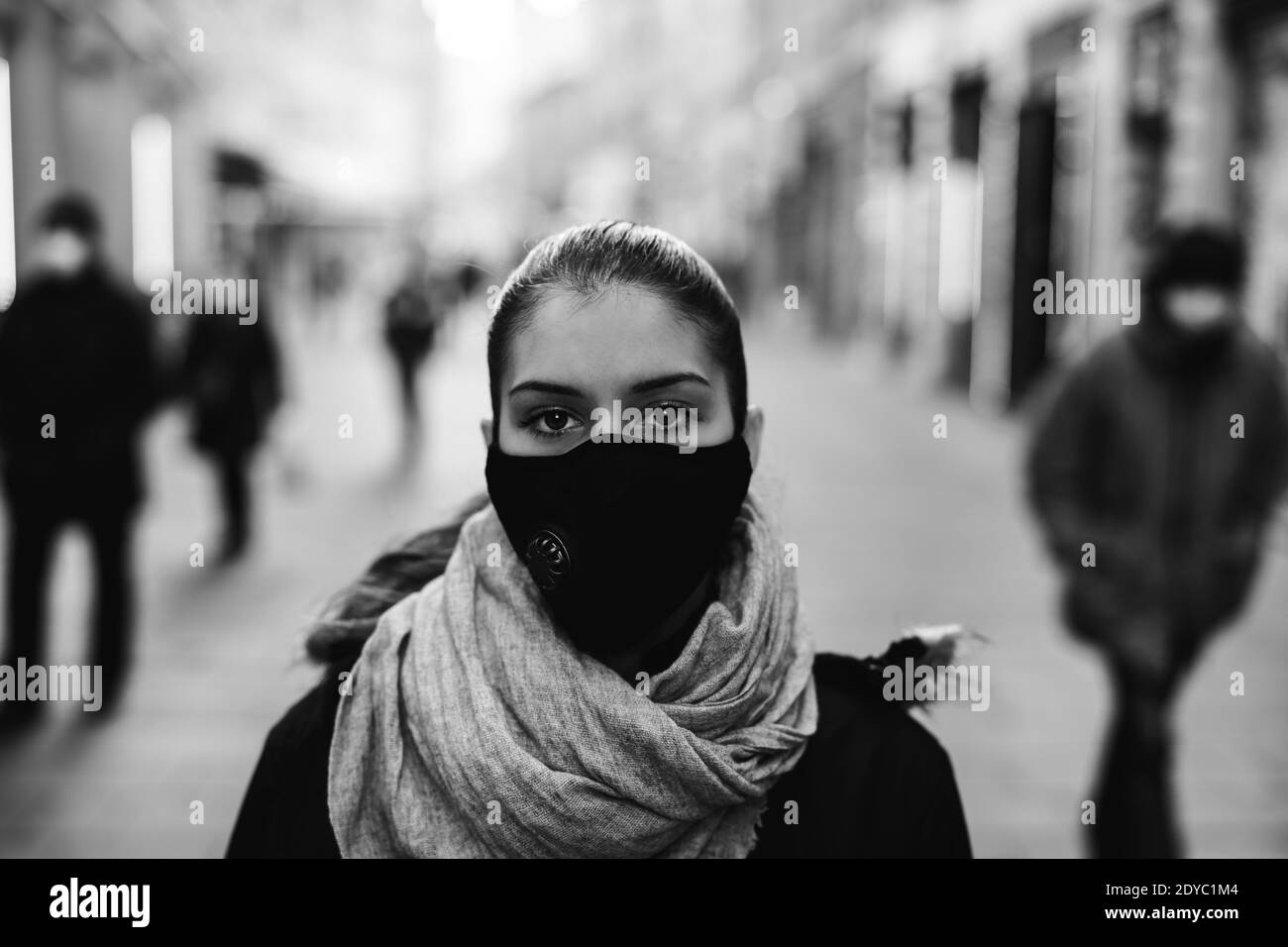Worried depressed woman walking to work in the public during the pandemic.Effect of the COVID-19.Protective measure,mask wearing.Air pollution filter Stock Photo