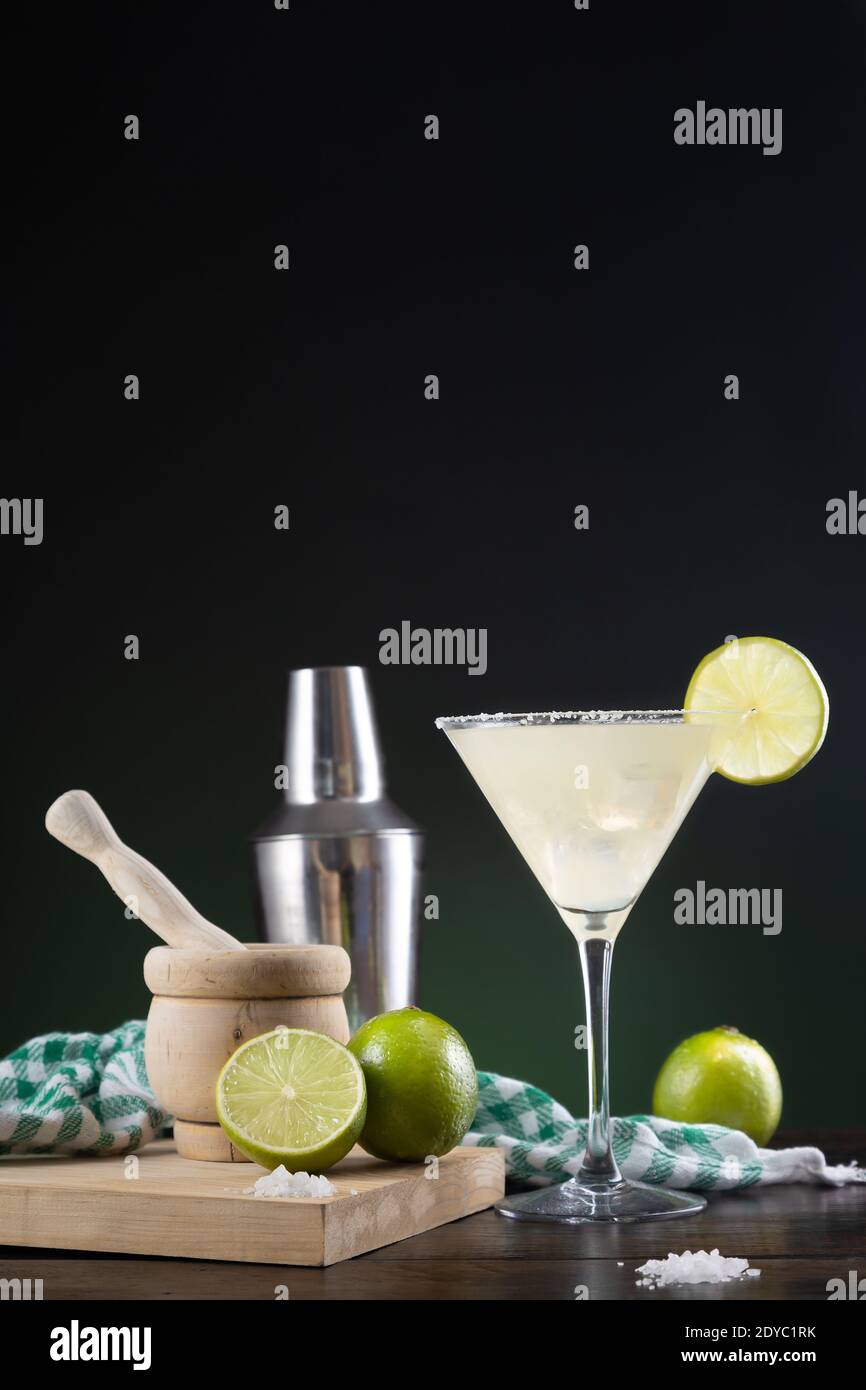 Typical Mexican margarita cocktail with limes and cocktail shaker on