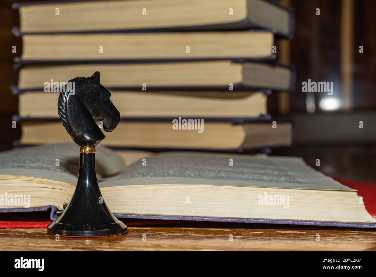 Knights move. Chess piece black knight on the background of an open book Stock Photo