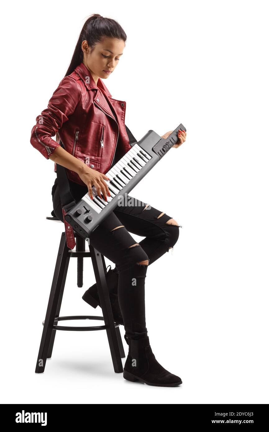 Female musician playing a keytar and sitting on a tall ba chair isolated on white background Stock Photo