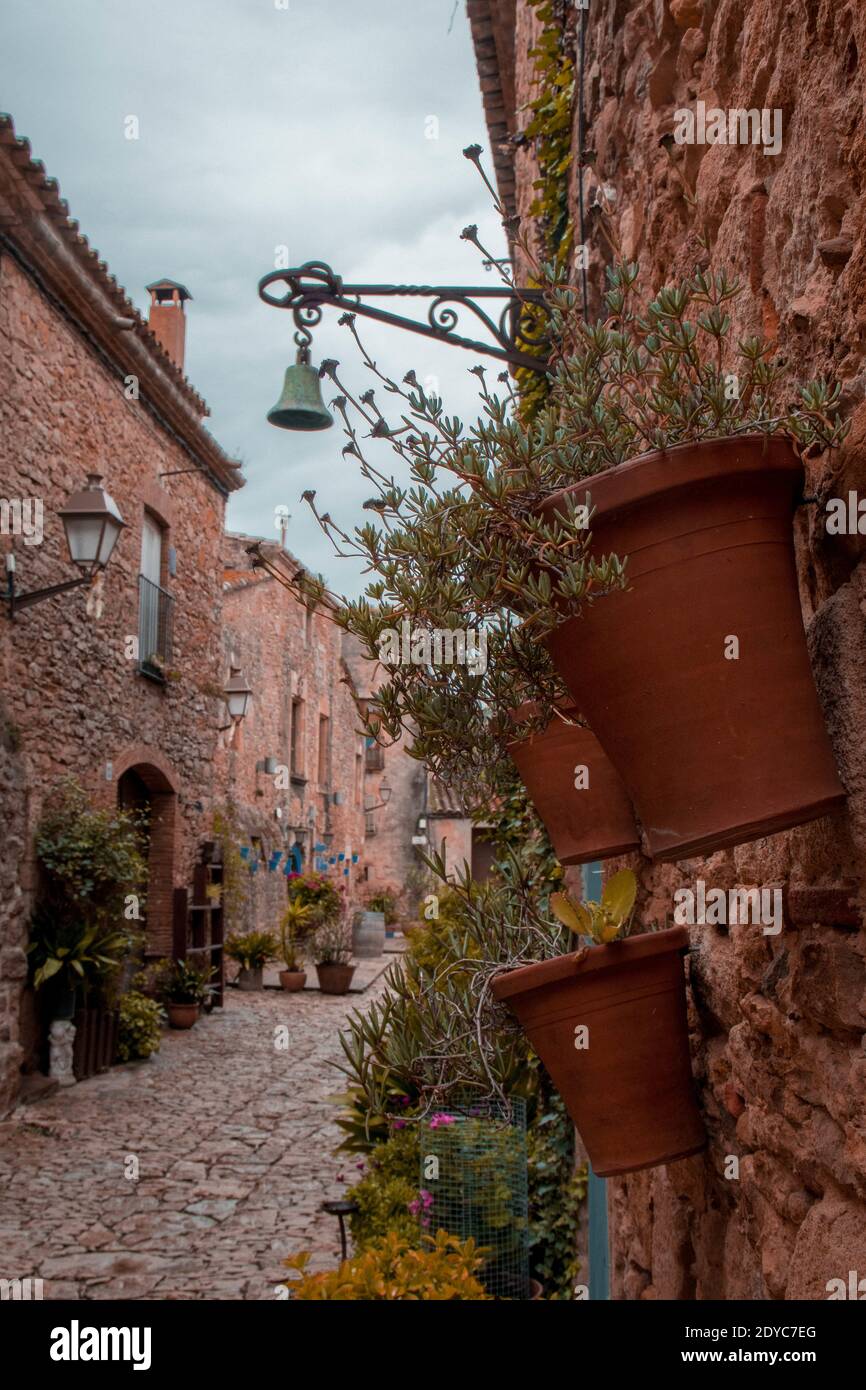 A vertical shot of a narrow street between the stone buildings with ...