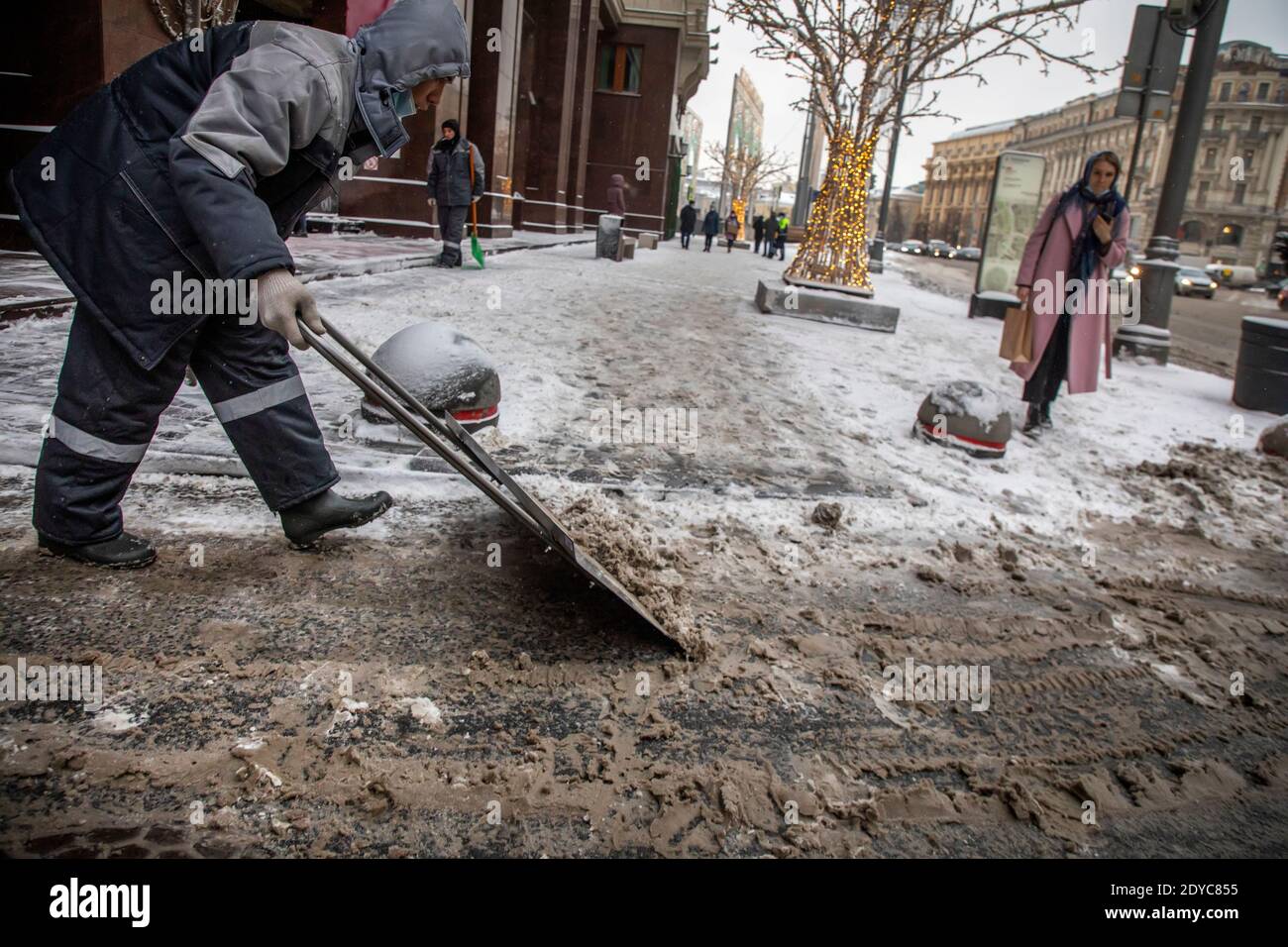 Moscow, Russia. 25th of December, 2020 An employee of a municipal service is engaged in cleaning the fallen snow on Okhotny Ryad street in the center of Moscow, Russia Stock Photo