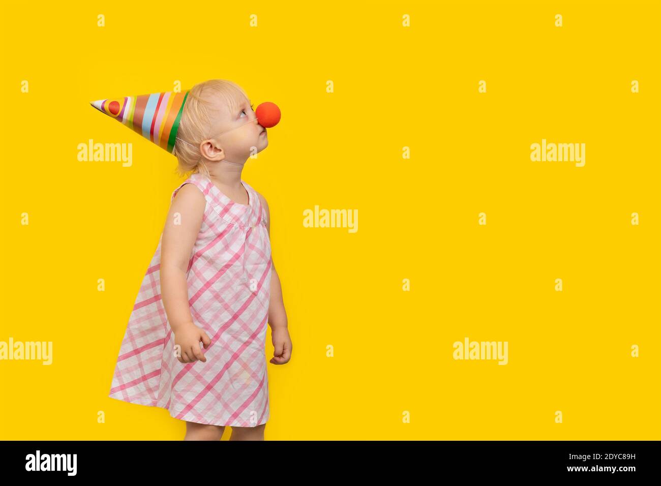 Bambina in parrucca clown sorridente e guardando la telecamera, mento su  mani e corpo a metà, isolato Foto stock - Alamy