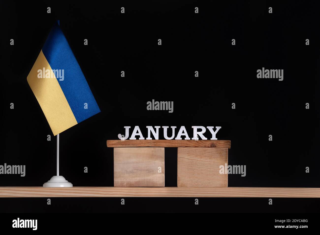 Wooden calendar of January with Ukrainian flag on black background
