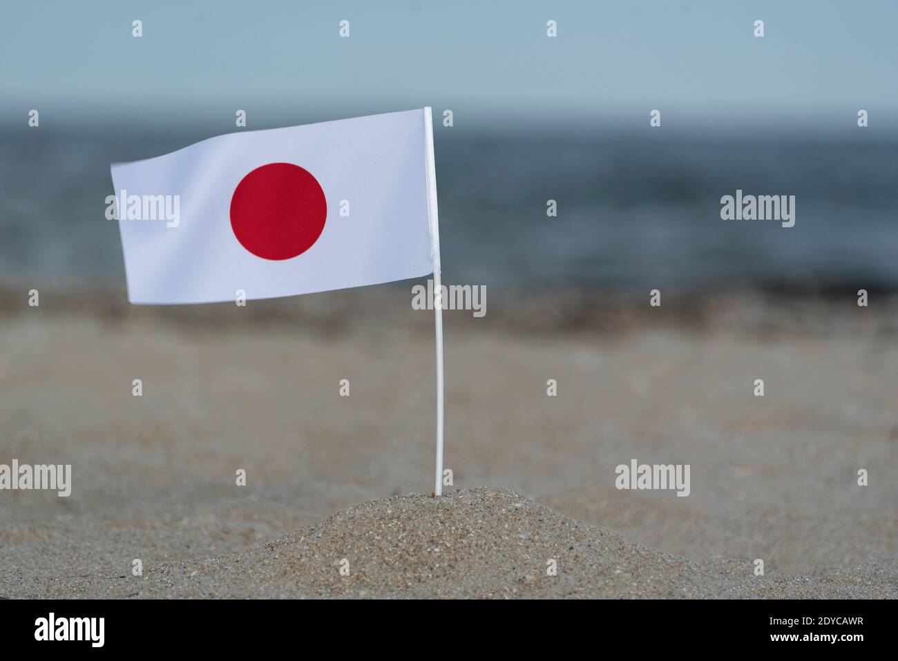 Flag of Japan on sea shore. White flag with red circle Photo - Alamy